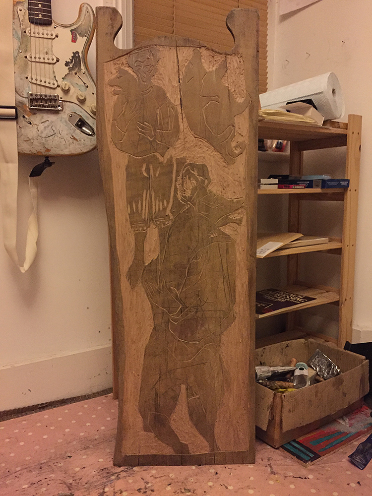 Two men, each carrying a pig virgin wood carving